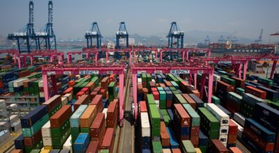 Operations At The BNCT Co. Container Terminal Ahead Of Trade Figures...Shipping containers sit stacked among gantry cranes in this aerial photograph taken above the BNCT Co. container terminal at Busan New Port in Busan, South Korea, on Thursday, July 30, 2015. South Korea is scheduled to release trade figures on Aug. 1. Photographer: SeongJoon Cho/Bloomberg